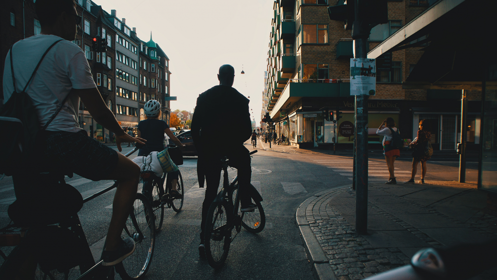 Personer som cyklar bland trafik.